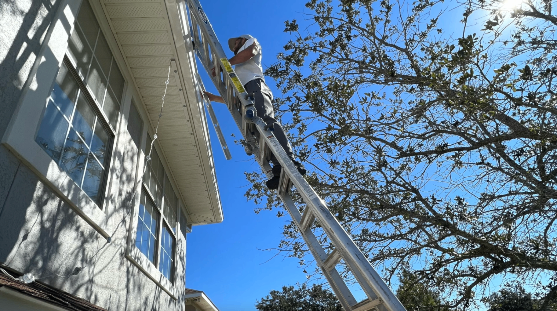 Latitude Lumens installer mounting permanent lighting on a roofline